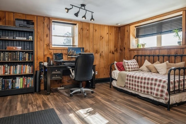 bedroom with wooden walls and dark hardwood / wood-style floors