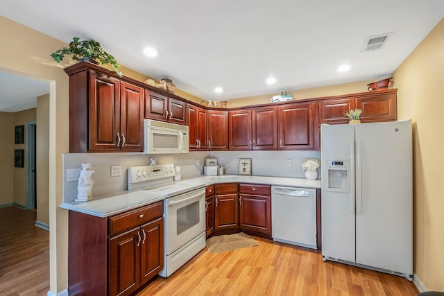 kitchen featuring white appliances and light hardwood / wood-style flooring