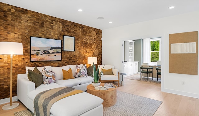 living area featuring light wood-style floors, baseboards, and recessed lighting