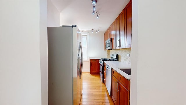 kitchen featuring sink, decorative backsplash, light hardwood / wood-style floors, and appliances with stainless steel finishes