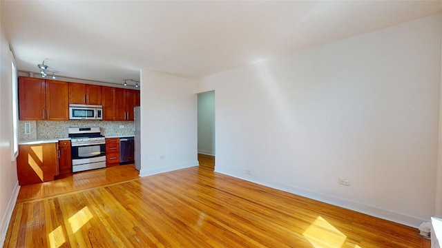 kitchen with stainless steel appliances, tasteful backsplash, and light hardwood / wood-style flooring