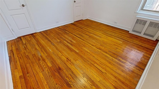 unfurnished room with radiator and light hardwood / wood-style flooring