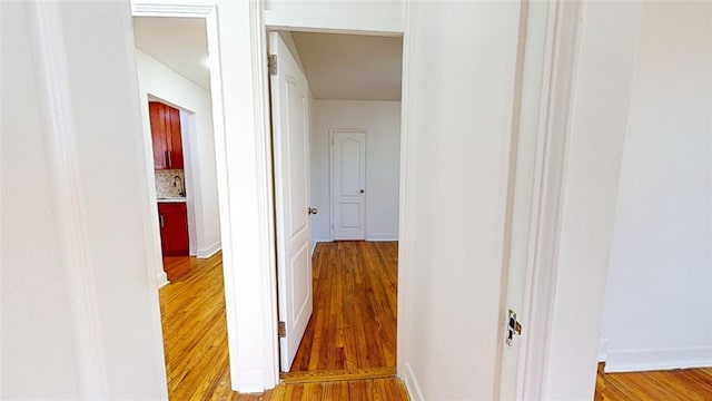 hallway with sink and hardwood / wood-style floors