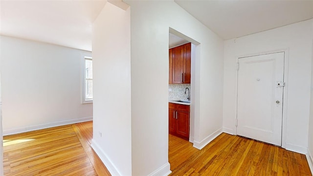 corridor with sink and light hardwood / wood-style floors