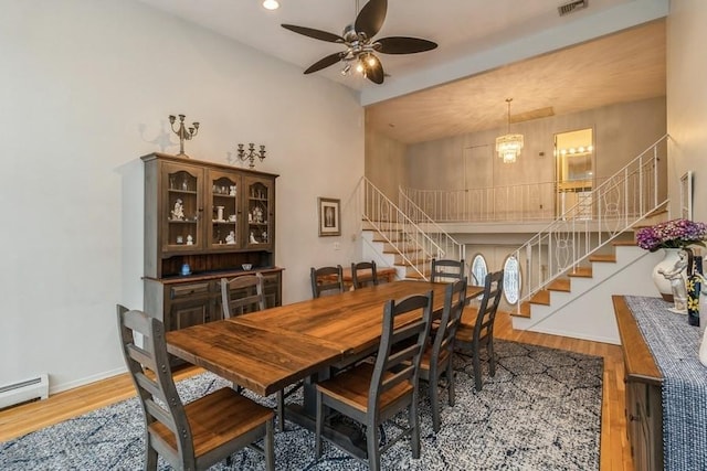 dining space with hardwood / wood-style flooring, a baseboard radiator, and ceiling fan