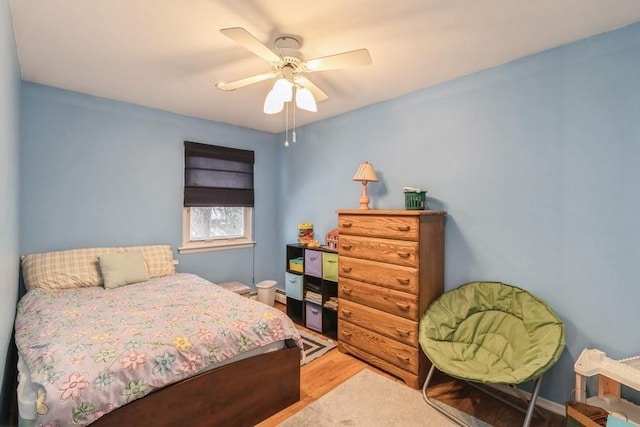 bedroom featuring ceiling fan, wood-type flooring, and a baseboard radiator