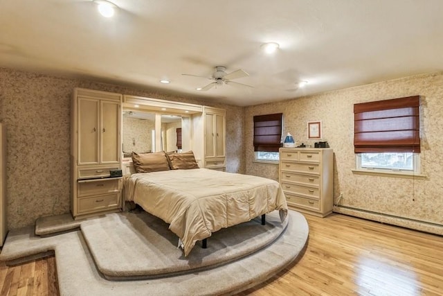 bedroom with light hardwood / wood-style flooring and a baseboard radiator