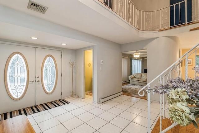 tiled entrance foyer with a baseboard radiator and french doors