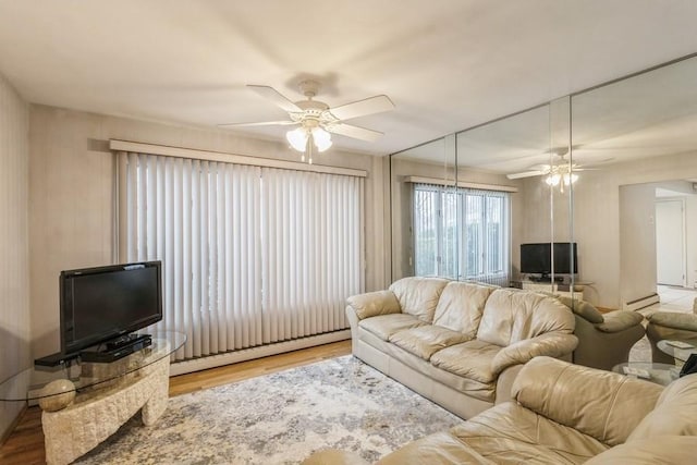 living room with ceiling fan, wood-type flooring, and a baseboard heating unit