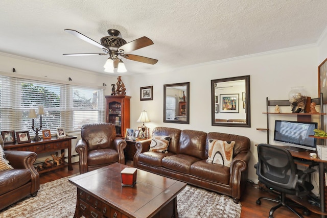 living room featuring a textured ceiling, baseboard heating, ornamental molding, ceiling fan, and hardwood / wood-style floors