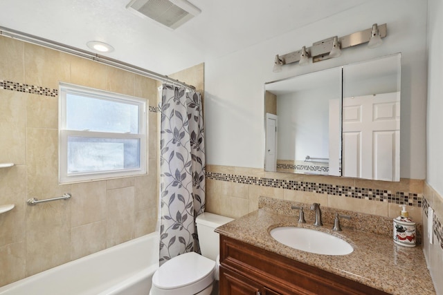 full bathroom with shower / bathtub combination with curtain, vanity, toilet, and tile walls