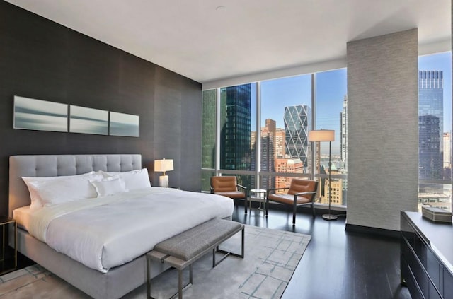 bedroom featuring a wall of windows and dark hardwood / wood-style floors