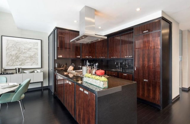 kitchen featuring sink, dark hardwood / wood-style floors, island range hood, and dark brown cabinetry