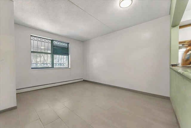 empty room featuring a textured ceiling and a baseboard heating unit