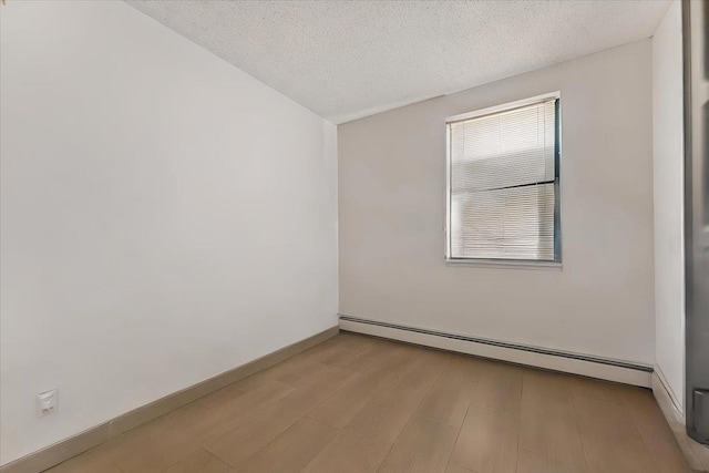 unfurnished room featuring plenty of natural light, light wood-type flooring, a textured ceiling, and baseboard heating