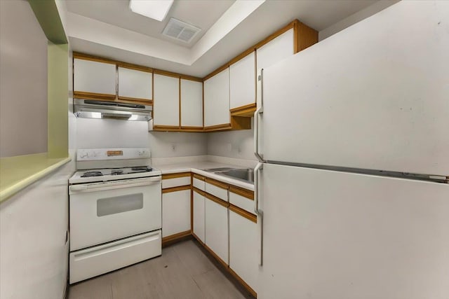 kitchen featuring sink, white appliances, and white cabinets