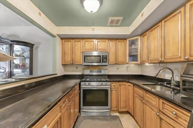 kitchen featuring stainless steel appliances, light tile patterned flooring, and sink