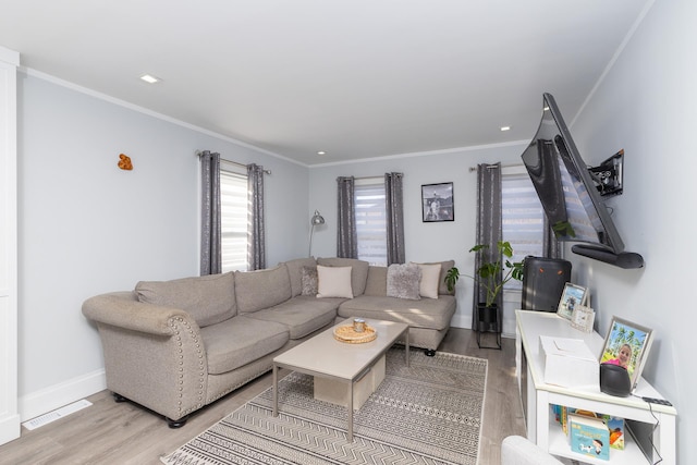 living room with crown molding and light hardwood / wood-style flooring