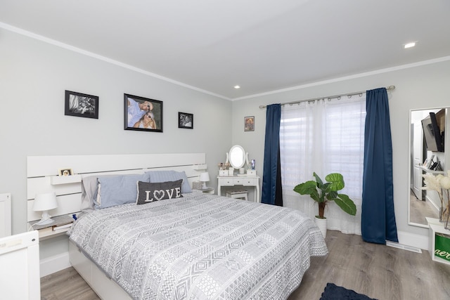 bedroom with crown molding and hardwood / wood-style floors