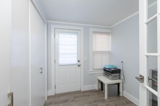 doorway with ornamental molding and light hardwood / wood-style floors