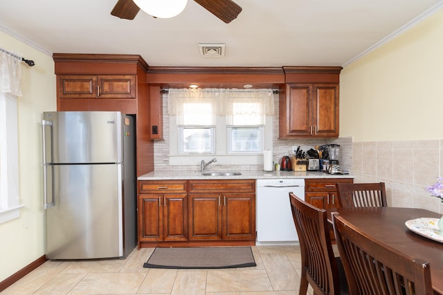 kitchen featuring crown molding, sink, stainless steel fridge, and white dishwasher