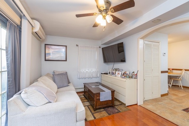 living room with wood-type flooring, a wall mounted AC, ceiling fan, and a baseboard radiator