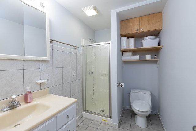 bathroom featuring walk in shower, toilet, tile walls, vanity, and tile patterned flooring