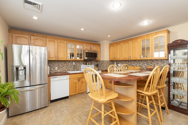 kitchen with sink, decorative backsplash, and stainless steel appliances