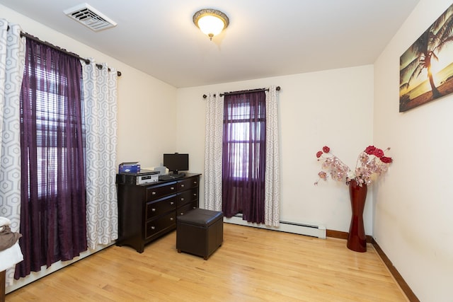 interior space featuring a baseboard radiator and light hardwood / wood-style flooring