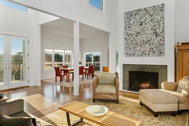 living room featuring french doors, wood-type flooring, and a high ceiling