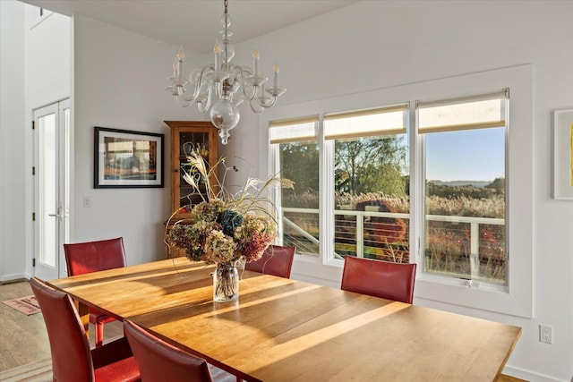 dining space with wood-type flooring and a notable chandelier