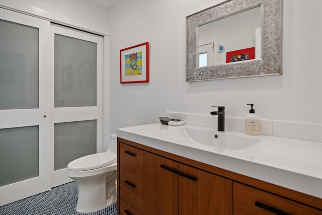 bathroom featuring vanity, tile patterned flooring, and toilet