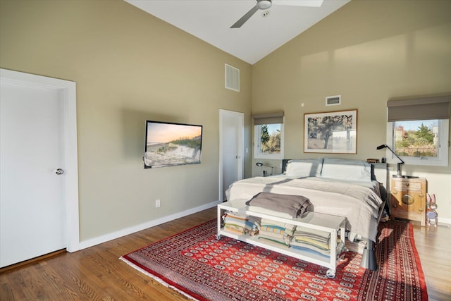 bedroom with ceiling fan, high vaulted ceiling, hardwood / wood-style floors, and multiple windows