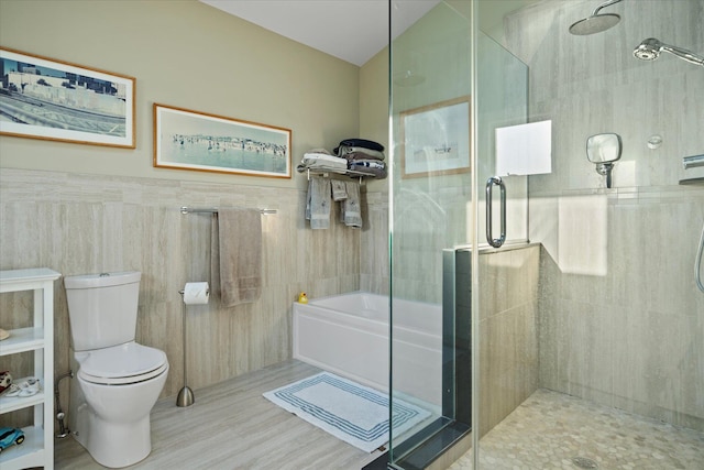 bathroom with hardwood / wood-style flooring, separate shower and tub, tile walls, and toilet