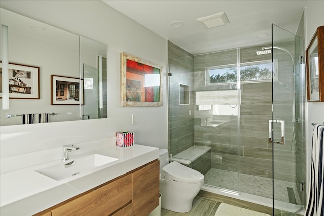 bathroom featuring vanity, toilet, and a shower with shower door