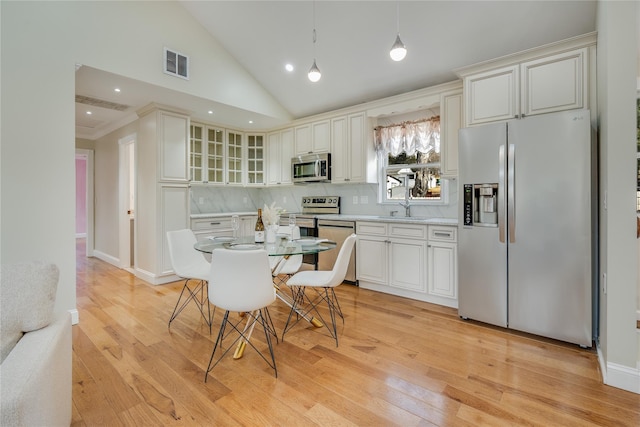 kitchen featuring white cabinetry, stainless steel appliances, and light wood-type flooring