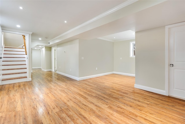 below grade area featuring light wood-style flooring, crown molding, stairway, and baseboards