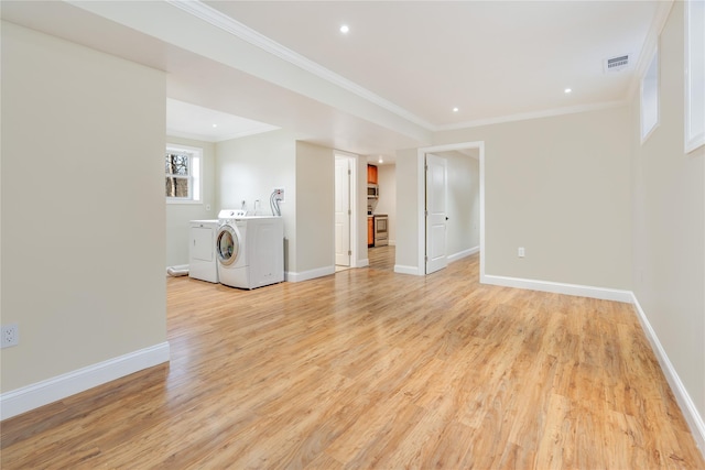 interior space featuring separate washer and dryer, ornamental molding, and light hardwood / wood-style floors