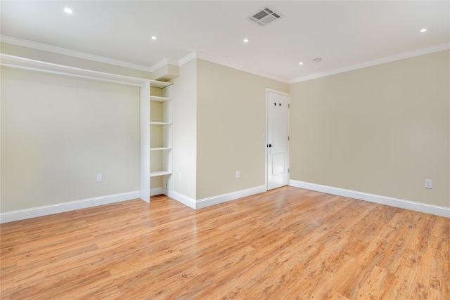 spare room with ornamental molding and light wood-type flooring