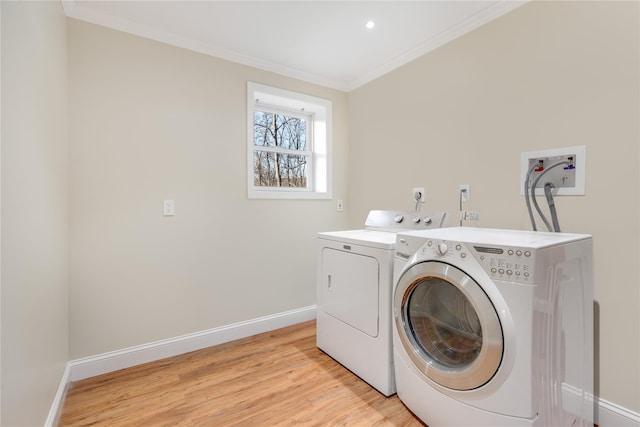 laundry room with light wood-style flooring, laundry area, baseboards, independent washer and dryer, and crown molding