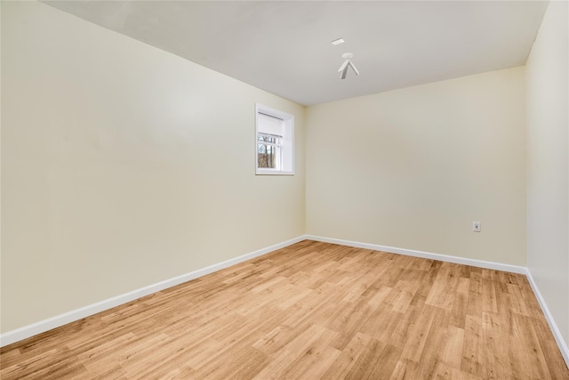 empty room with light wood-style floors and baseboards