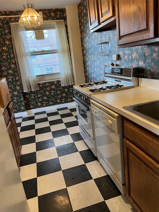 kitchen with white appliances, a chandelier, and hanging light fixtures