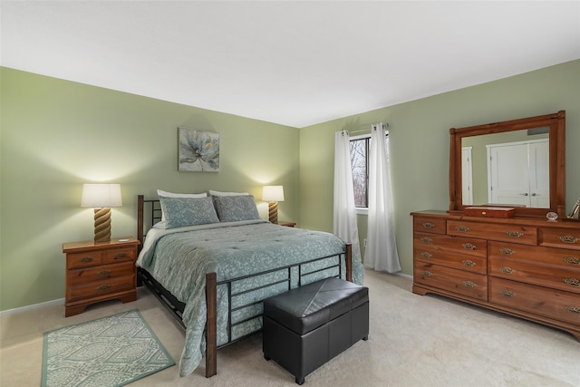 bedroom with light carpet and baseboards