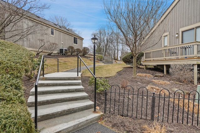 view of yard featuring central AC and fence