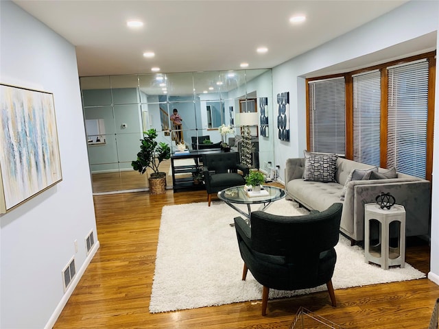 living area featuring recessed lighting, visible vents, and wood finished floors