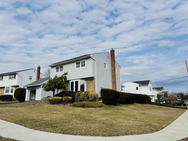 view of front facade featuring stone siding, a chimney, and a front yard