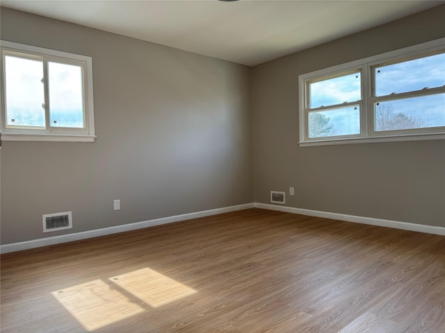 unfurnished room featuring visible vents and baseboards