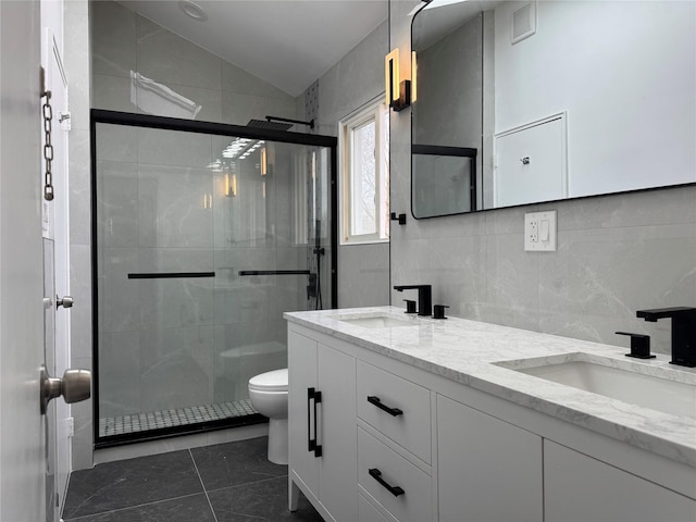 bathroom with a sink, lofted ceiling, toilet, and a shower stall