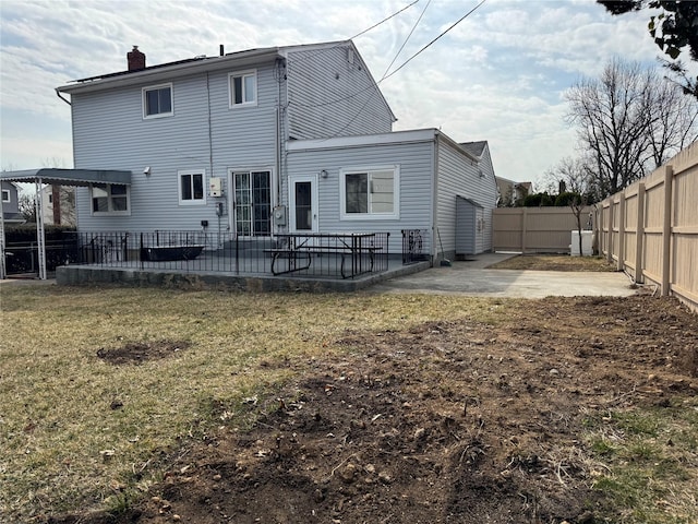 back of property featuring a patio area, a yard, a chimney, and a fenced backyard