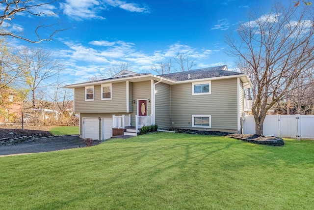 bi-level home featuring a garage and a front lawn